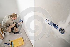 Young man, worker glueing wallpapers on concrete wall. Repair the apartment. Home renovation concept. White Wallpaper