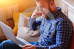 Young man working absorbed on laptop at home