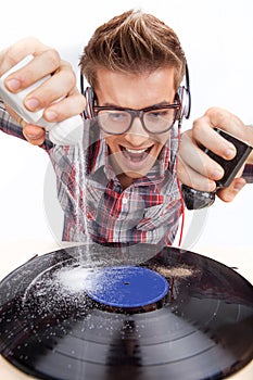 Young man working as dj with ear-phones and glasses.