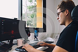 young man working as a graphic designer from home on his computer.