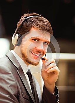 Young man working at callcenter, using headset