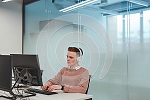 Young Man Working at Computer Desk in Office