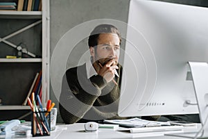 Young man working with computer at desk in office
