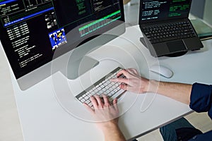 Young Man Coding Software on Desktop Computer in Office Setting