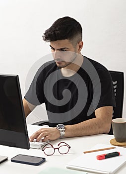 Young man working with computer in his home office.education.business.e-commerce