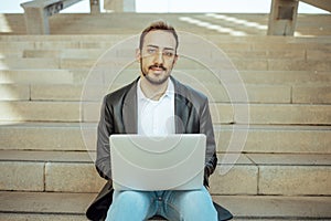 Young man working with computer and looking at the camera