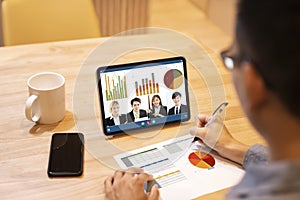 Young man working at home and using tablet computer with video conference