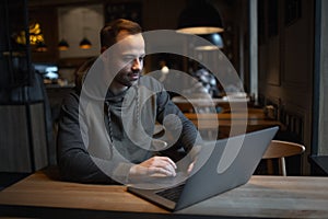 Young man working at laptop in cafe