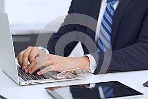 Young man working with laptop computer, man`s hands on notebook, business person at workplace