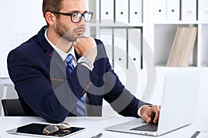 Young man working with laptop computer, man`s hands on notebook, business person at workplace