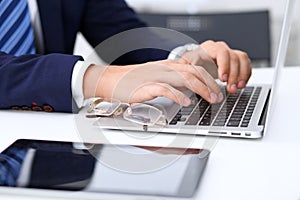 Young man working with laptop computer, man`s hands on notebook, business person at workplace