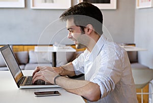 Young man working on laptop indoors
