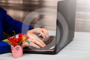 Young man working with laptop, man`s hands on notebook computer