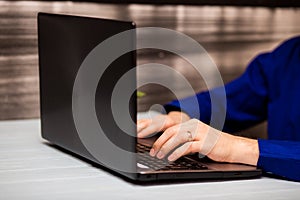 Young man working with laptop, man`s hands on notebook computer