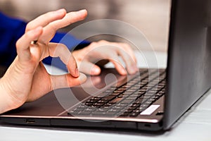 Young man working with laptop, man`s hands on notebook computer