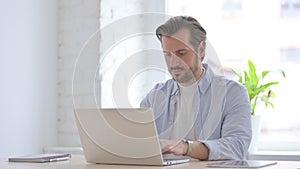 Young Man Working on Laptop in Office