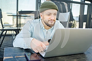 Young man working on laptop. Technology people work study concept. Guy use laptop in cafe.