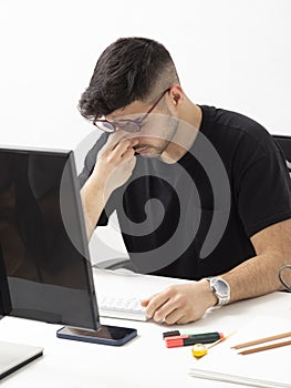 Young man working and looking tired in his home office.education.business.e-commerce