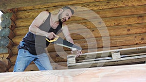 A young man is working with a metal saw.