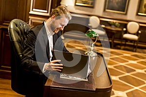 Young man working in the office with antique furniture