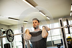 Young man working out with barbells in the gym