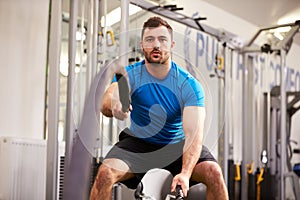 Young man working out with battle ropes at a gym