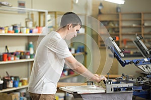 Young man working with squeegee on factory