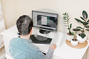 Young man working at a table with a computer on his working place. working at home. freelancer