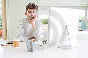 Young man working using computer thinking looking tired and bored with depression problems with crossed arms