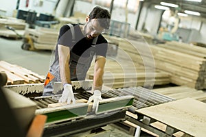 Young man works in a factory for the production of furniture