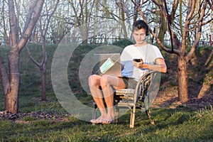 Young man works from home during the epidemic, on the laptop in the garden