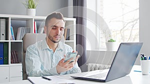 Young Man Works while Sitting in front of a Computer at Home. The Workplace of a Professional Worker, Freelancer or