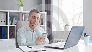 Young Man Works while Sitting in front of a Computer at Home. The Workplace of a Professional Worker, Freelancer or