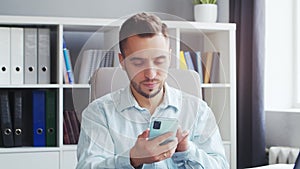 Young Man Works while Sitting in front of a Computer at Home. The Workplace of a Professional Worker, Freelancer or