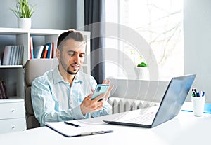 Young Man Works while Sitting in front of a Computer at Home. The Workplace of a Professional Worker, Freelancer or