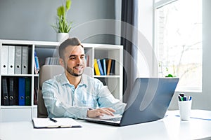 Young Man Works while Sitting in front of a Computer at Home. The Workplace of a Professional Worker, Freelancer or
