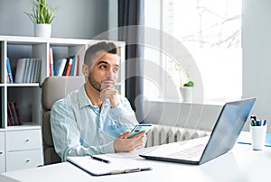 Young Man Works while Sitting in front of a Computer at Home. The Workplace of a Professional Worker, Freelancer or