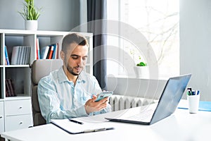 Young Man Works while Sitting in front of a Computer at Home. The Workplace of a Professional Worker, Freelancer or
