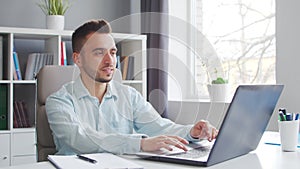 Young Man Works while Sitting in front of a Computer at Home. The Workplace of a Professional Worker, Freelancer or