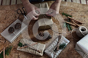 Young man wrapping his chic modern Christmas gifts