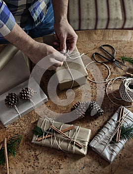 Young man wrapping his chic modern Christmas gifts