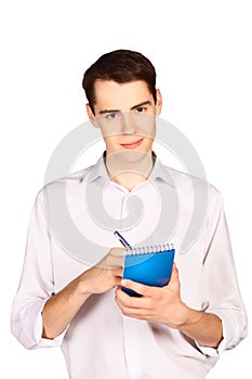 Young man writes in blue notebook