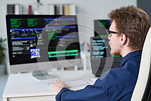 Young Man Writing Code on Computer in Office Setting