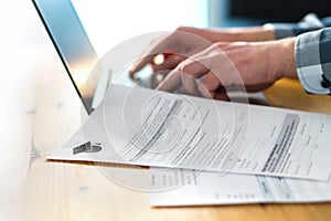 Young man writing college or university application form.