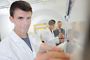 Young man writing on easel