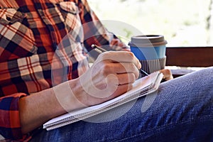 Young man writing in a notebook