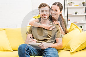 young man writing in notebook while his girlfriend