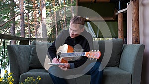 Young Man Writing Song Outside Glamping Tent