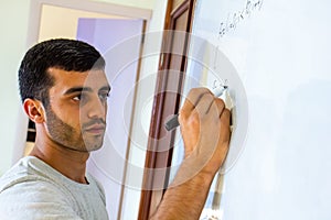 Young man writing on a whiteboard