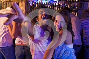 Young man and young woman dancing in a nightclub